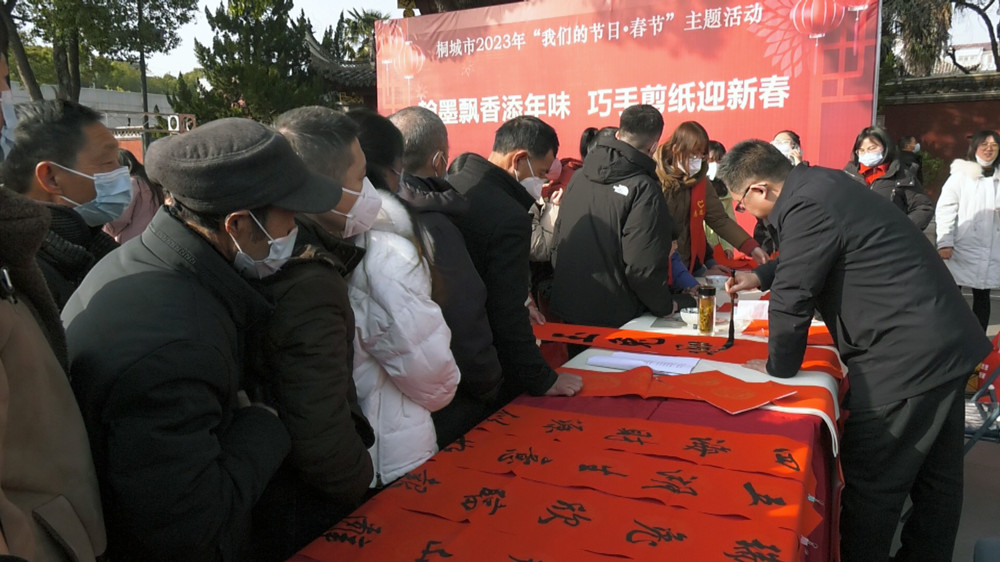 图为市书法协会的书法家们正在挥毫泼墨为市民免费书写春联 .jpg