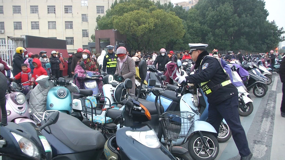 /uploads/image/2023/02/09/9f24ba9c156c084ad22846ca37afc9c0.jpg 交警护学岗 交警在整理乱停放的电瓶车.jpg