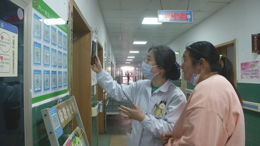 /uploads/image/2023/03/20/9f0cbfbba4872625a950efca1e094bf2.jpg 图为医护人员在指导患者家属扫描健康二维码.jpg