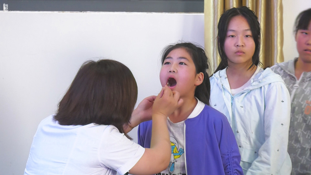 图为现场医生正在为学生们做口腔健康检查.jpg