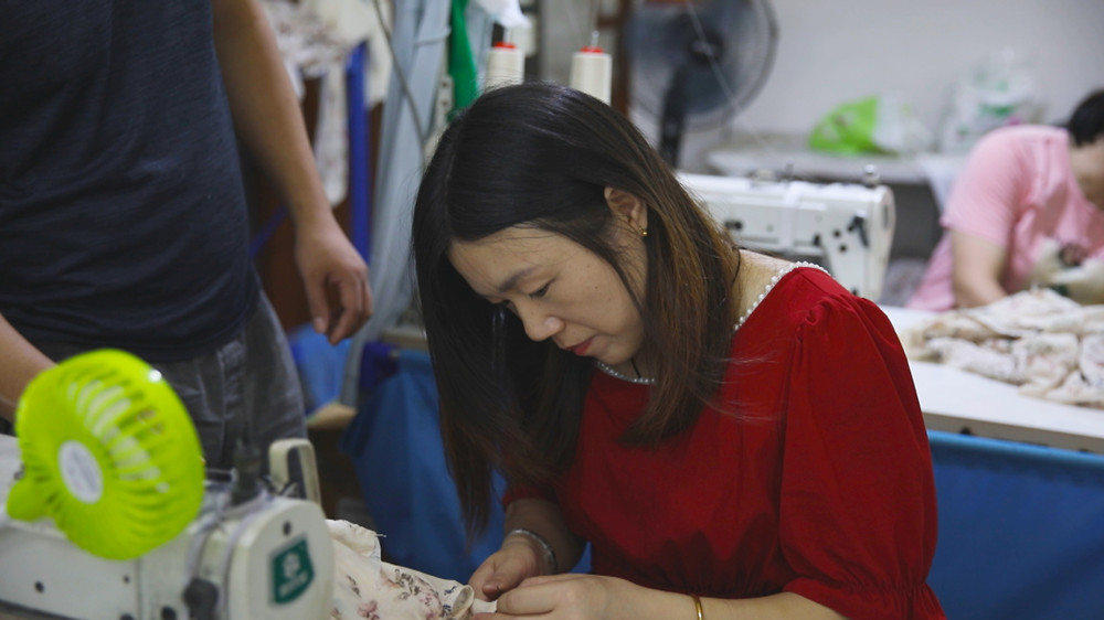 /uploads/image/2023/08/17/0b8781dd6adb1b858332c64388a25a02.jpg 图为正在家楼下服装厂里工作的郭金妹.jpg