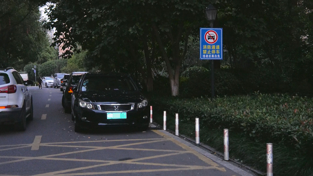 图为某小区内占用消防通道停车的车辆，而在一旁醒目的“消防通道 禁止停车”的标语却被熟视无睹.jpg