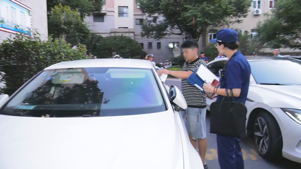 图为检查人员正在对一占用消防通道车主进行教育警告.jpg