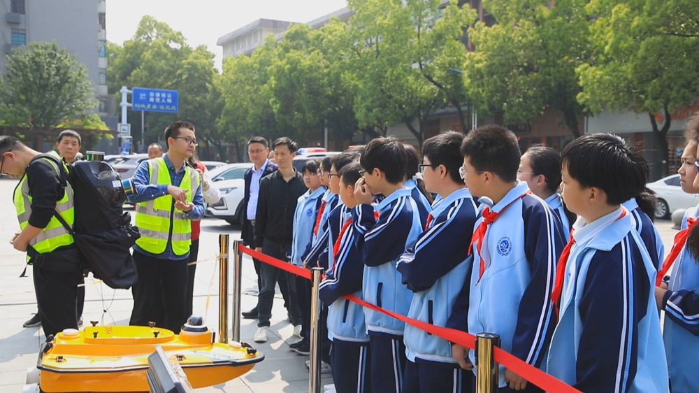 图为安徽省第四测绘院的志愿者正在为中小学生介绍测绘仪器.jpg