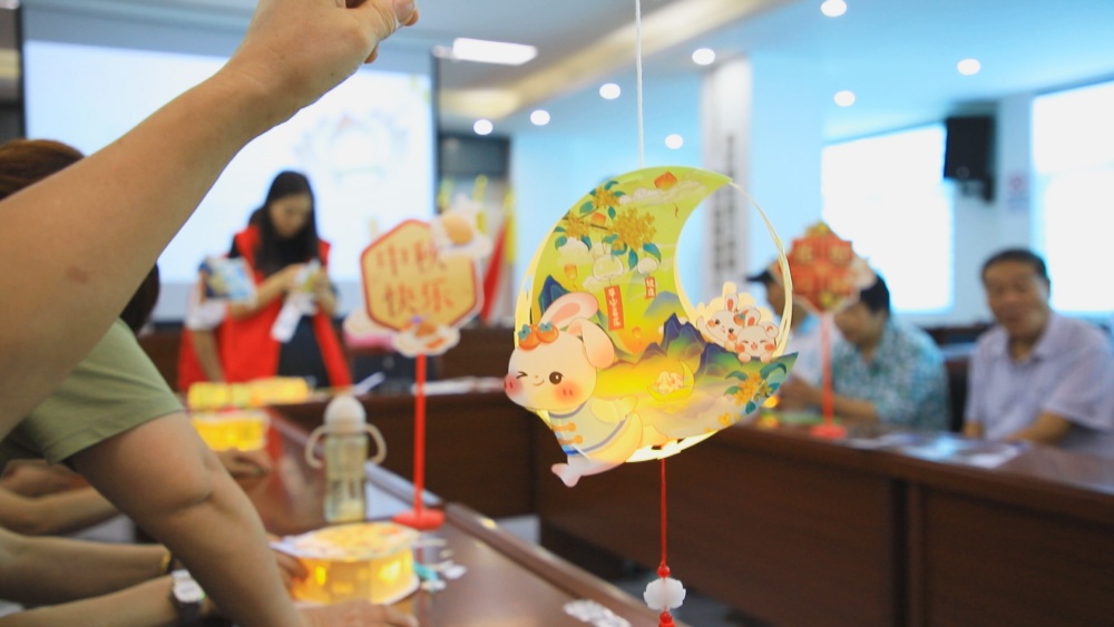 /uploads/image/2024/09/14/c2cbc796a034a466e78b6226d6f1cb78.jpg 图为居民正在展示制作完成的花灯1.jpg