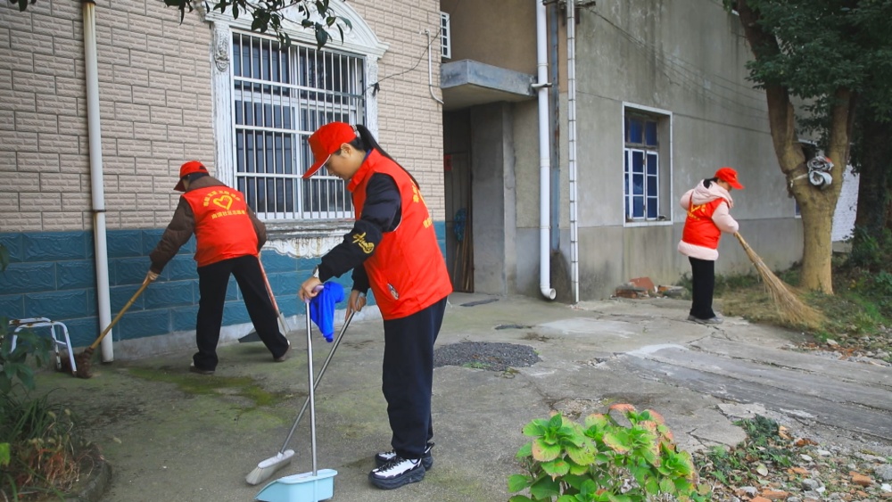 图为龙眠街道南演社区志愿者正在为社区老人家打扫门前庭院.jpg