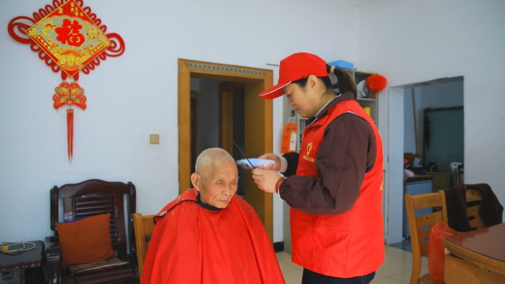 图为龙眠街道南演社区志愿者正在为社区老人免费理发.jpg