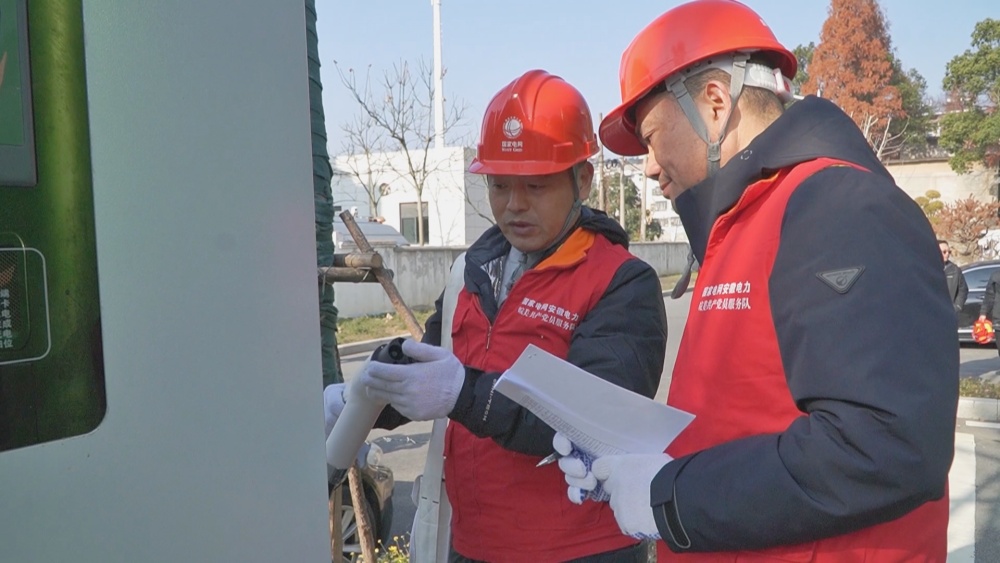 图为工作人员在检查充电设备.jpg