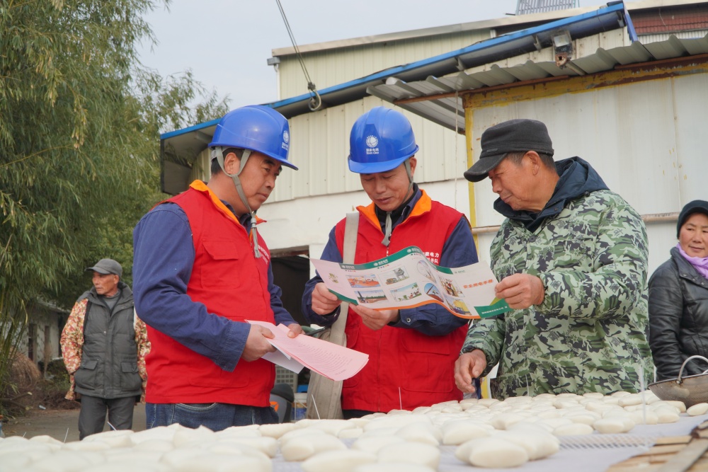 图中工作人员向居民科普用电安全知识.JPG