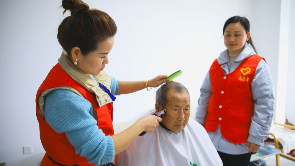 /uploads/image/2025/03/03/f474d51cb6ccec295fef32205843b3c3.jpg 图为义诊志愿者为社区行动不便老年人提供上门免费理发现场.jpg