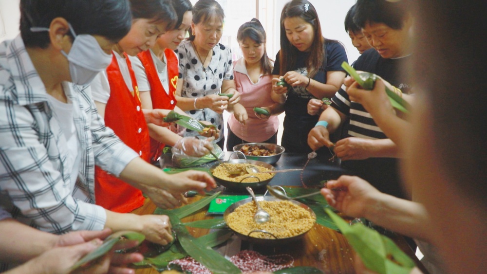 /uploads/image/2025/05/28/80a339013a9a3c43bcaa8dcd97c73075.jpg 图为社区工作人员及社区居民共同手工包粽子.jpg