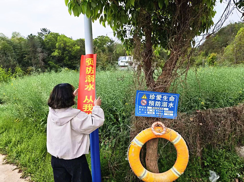 图为黄岗村工作人员张贴防溺水标语_副本.jpg