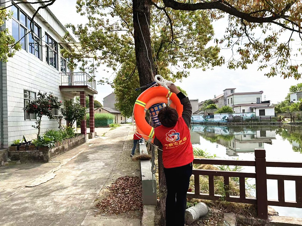 图为志愿者正在悬挂新的救生圈_副本.jpg