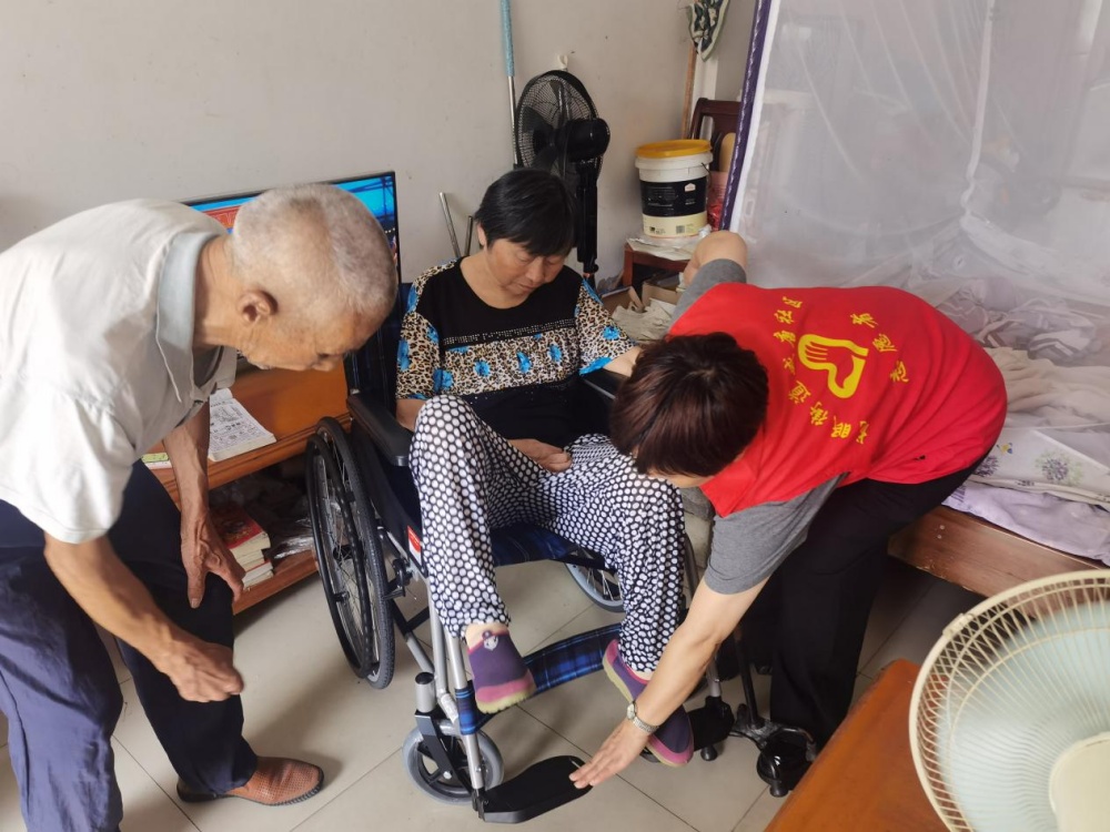 图为社区工作人员为周奶奶调试轮椅_副本.jpg
